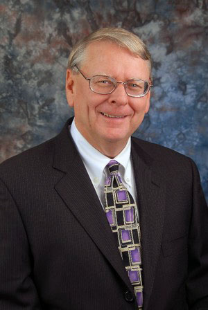 Bill Sanderson, the museum's founder, in a dark suit and patterned tie.